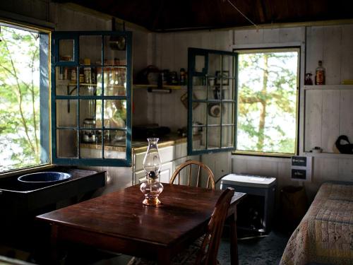 a kitchen with a table and a sink and two windows at Little Diamond Island - on Private Island in Frenchs Corner
