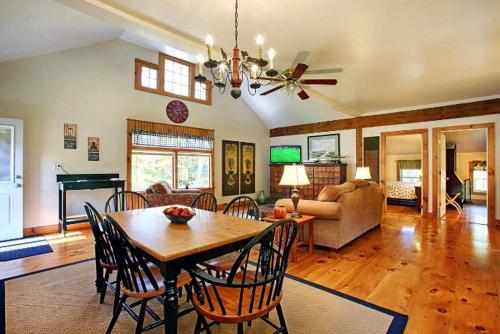 a dining room and living room with a table and chairs at Light-Filled, Well-Appointed Mountain Cabin for a Vacation in Wells, Vermont in Wells