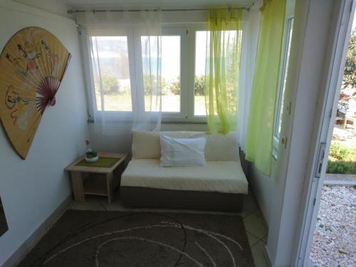 a room with a bench in a room with windows at Apartments Viva Ciovo in Slatine