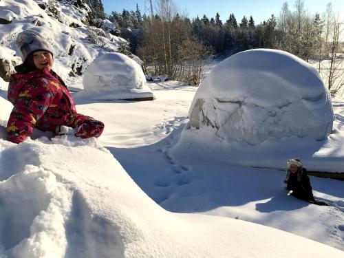 una mujer sentada en un montón de nieve en Luxury Dome with Ski-In/Ski-Out Access in Pori for a Holiday in Finland, en Pori