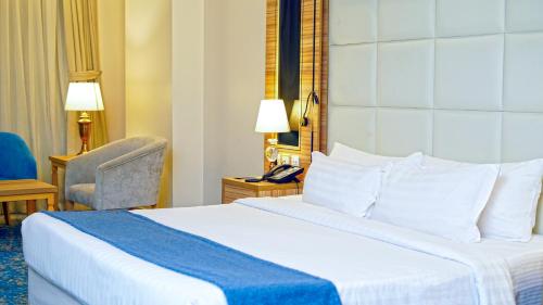 a hotel room with a bed and a chair at Casa Diora Hotel Al Naseem in Jeddah