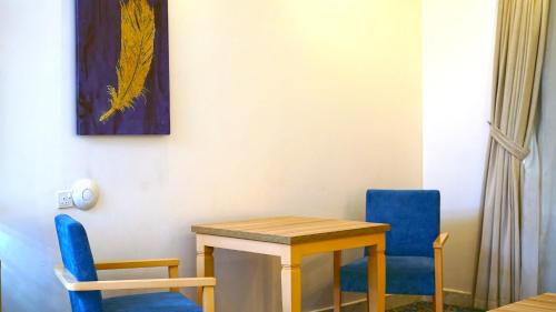 a room with a table and two blue chairs at Casa Diora Hotel Al Naseem in Jeddah