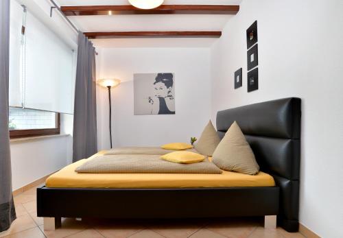 a bedroom with a bed with a black leather headboard at Haus Daniela Superior in Cochem