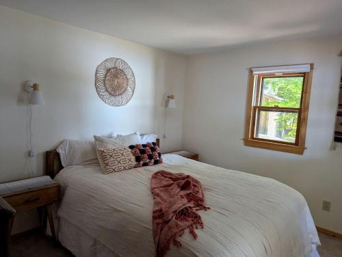 une chambre avec un lit avec des draps blancs et une fenêtre dans l'établissement Quaint Lakeside Cabin for a Peaceful Family Getaway Surrounded by Nature by Province Lake in New Hampshire, à Ossipee