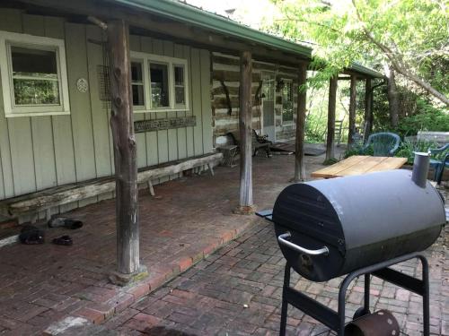 a grill on a brick patio in front of a house at Secluded Cabin Rental near the Spectacular Ozarks of Arkansas in Duff