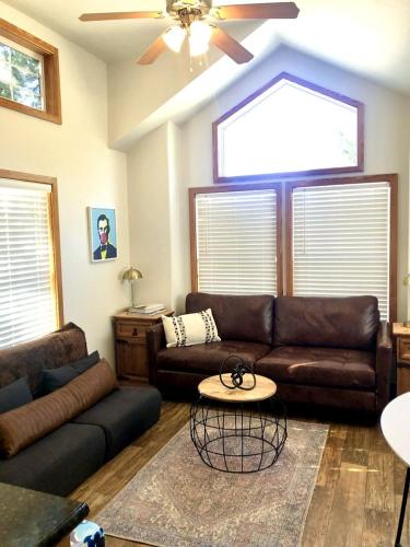 a living room with a leather couch and a table at Charming Cabin on a Glamping Resort with Swimming Pool in Austin, Texas in Cedar Valley