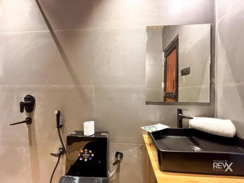 a bathroom with a sink and a mirror at Anupraas Resort in Lansdowne