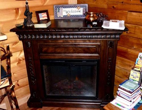 una chimenea en una habitación con una pared de madera en Rustic Log Cabin For a Group Getaway near Lake Cumberland in Kentucky, en Liberty