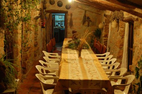 - une grande table avec des chaises blanches dans l'établissement La Casa de la Montaña, à Cortes de Arenoso