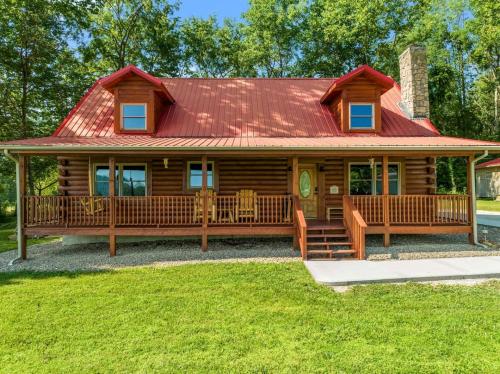 einem Blockhaus mit rotem Dach in der Unterkunft Chic Wooden Cabin with Hot-Tub, Ping-Pong Table and Fire Pit in Stanton, Kentucky in Stanton