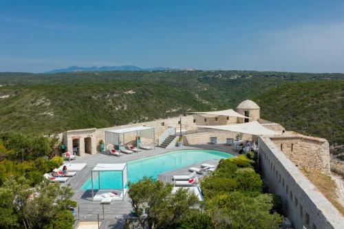 un complexe avec piscine sur une colline dans l'établissement Hotel Spa Genovese, à Bonifacio