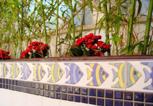 a balcony with red flowers on top of a wall at Mare Mare Suites in Mali Lošinj