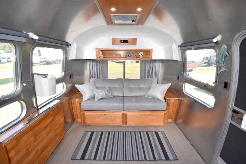 an interior of an rv with a couch in it at Classy Airstream Land Yacht Rental with Modern Amenities near Gatlinburg, Tennessee in Shady Grove