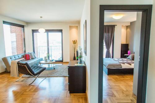 Modern Apartment in City Center في كراكوف: غرفة معيشة مع أريكة وسرير في غرفة