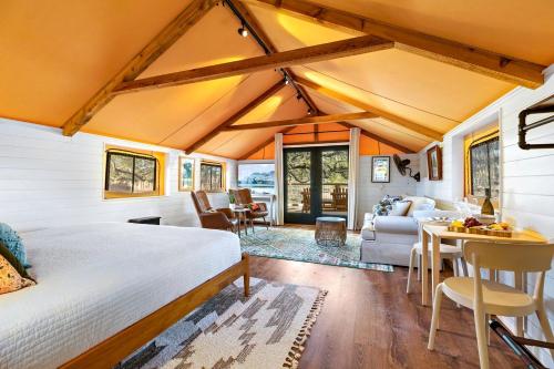 a bedroom with a bed and a living room at Beautiful Glamping Tented Cabin in Ingram, Texas, with Access to the Guadalupe River in Hunt