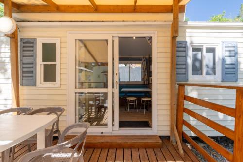 a screened in porch with a table and chairs at Les Rives d’Auzon Mobil-home 6 pers in Lavilledieu