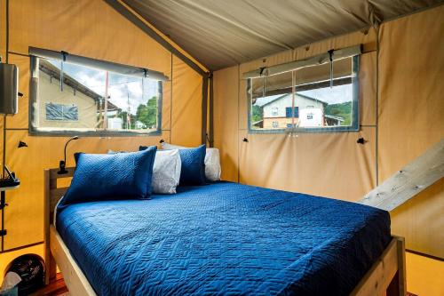 a bedroom with a blue bed in a tent at Beautiful Secluded Tented Cabin with Fire Pit in Sevierville, Tennessee in Wear Valley