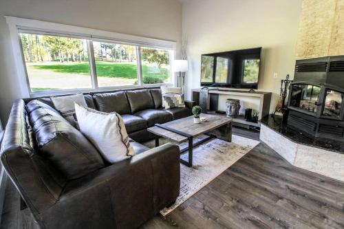a living room with a leather couch and a fireplace at Wonderful Vacation Rental by Golf Course in Columbia Falls, Montana in Country Estates Mobile Home Park