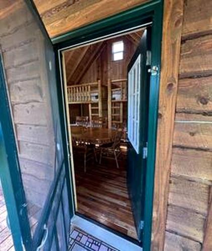 a glass door of a house with a dining room at Off-Grid Riverside Cabin in Belfast, NY that Sleeps 8 and Perfect Nature Escape in Oramel