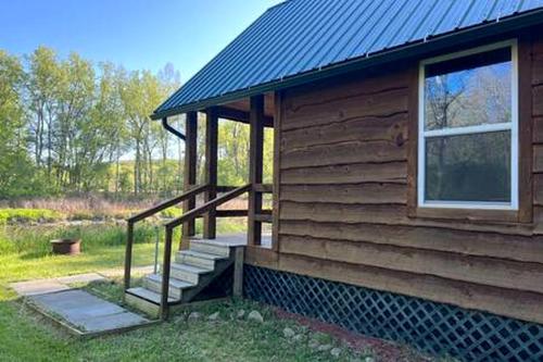 a cabin with a staircase on the side of it at Off-Grid Riverside Cabin in Belfast, NY that Sleeps 8 and Perfect Nature Escape in Oramel