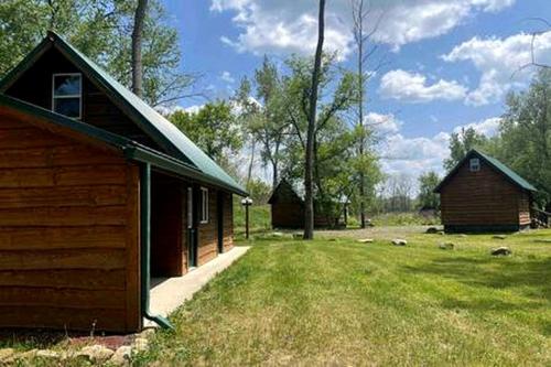 a barn and a house in a field at Off-Grid Riverside Cabin in Belfast, NY that Sleeps 8 and Perfect Nature Escape in Oramel