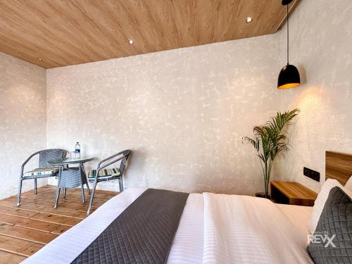 a bedroom with a bed and a table and chairs at Anupraas Resort in Lansdowne