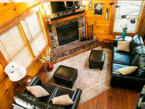 a living room with leather furniture and a fireplace at Log Cabin Rental with a Porch near Shenandoah National Park, Virginia in Grove Hill