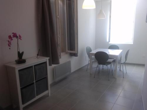Un comedor con mesa y sillas en Colombe, en LʼIsle-sur-la-Sorgue