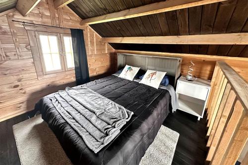 CantwellにあるSolar Powered Lakefront Twin Tiny Houses in Cantwell Alaska, Perfect for a Group Getaway to Denali National Parkの木造キャビン内のベッド1台が備わるベッドルーム1室を利用します。