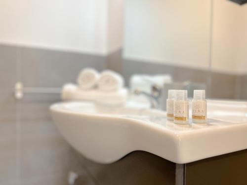 a bathroom sink with three toothbrushes on it at Suite Centro e Mare - Terrazza - Wifi - AC in Savona