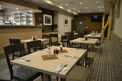 a dining room with tables and chairs in a restaurant at Wellness hotel Sauna in Malá Morávka