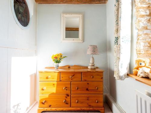 a dresser with a lamp on top of it in a room at 4 Bed in Gillingham 80670 in West Stour