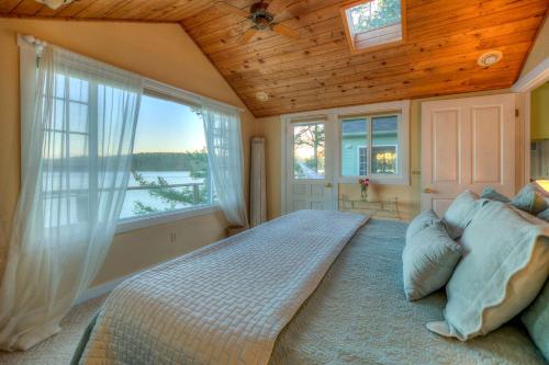ein Schlafzimmer mit einem großen Bett mit einem großen Fenster in der Unterkunft All Dream Cottages Romantic Island Getaways in Orcas