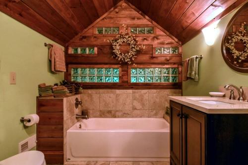 a bathroom with a tub and a sink at Charming Appalachian Mountain Cabin for Glamping near the Nantahala River in Aquone