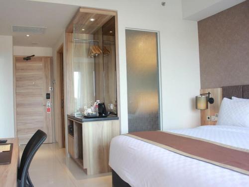 a hotel room with a bed and a small kitchen at Swiss-Belinn Karawang in Karawang