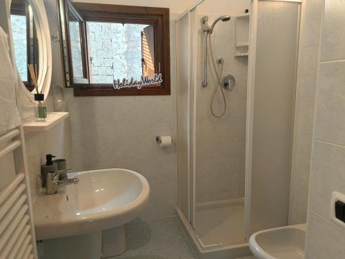 a white bathroom with a sink and a shower at Villa Bruna by Holiday World in Pisogne