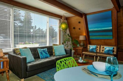 a living room with a couch and a table at Wonderful A frame Nestled Amidst Trees in Otter Rock, Oregon in Otter Rock