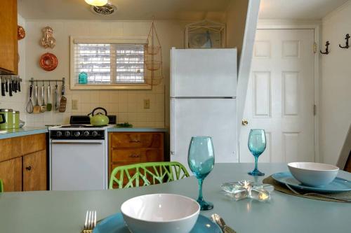 a kitchen with a white refrigerator and a table with glasses at Wonderful A frame Nestled Amidst Trees in Otter Rock, Oregon in Otter Rock