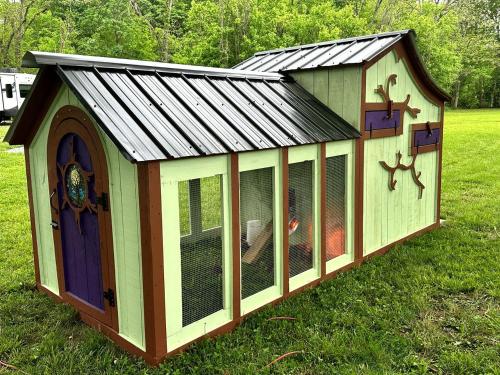 a chicken coop with a metal roof on the grass at Splendid Safari Tent Sanctuary near Smoky Mountains in Tennessee in Parrottsville