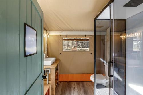 a small bathroom with a toilet and a sink at Splendid Safari Tent Sanctuary near Smoky Mountains in Tennessee in Parrottsville