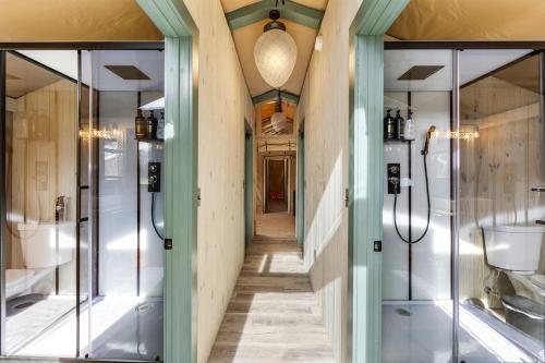 a hallway of a bathroom with glass doors at Splendid Safari Tent Sanctuary near Smoky Mountains in Tennessee in Parrottsville