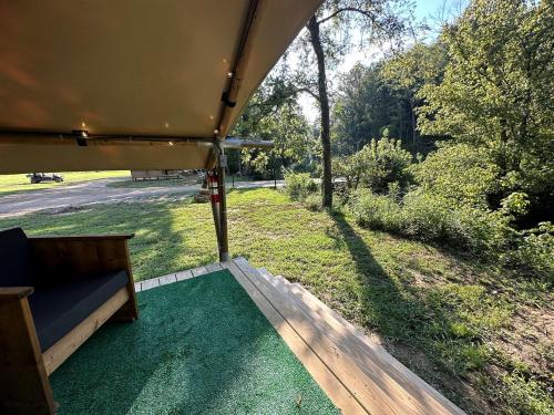a view of a porch with a couch on the grass at Splendid Safari Tent Sanctuary near Smoky Mountains in Tennessee in Parrottsville