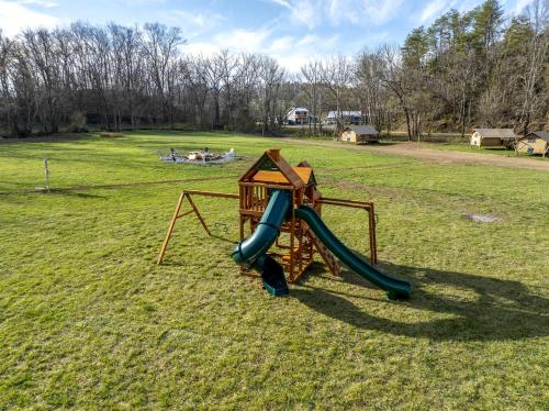 a playground with a slide in a field at Splendid Safari Tent Sanctuary near Smoky Mountains in Tennessee in Parrottsville