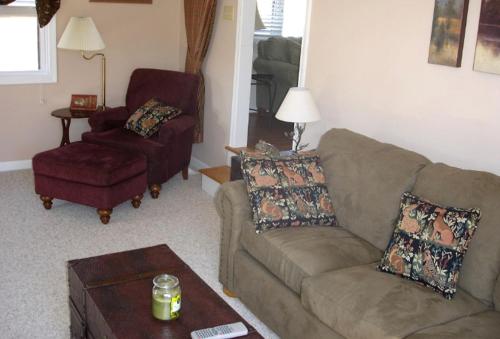 a living room with a couch and a chair at Charming Cottage Overlooking Gorgeous Citation Bass and Bream Pond near Charlottesville in Gordonsville