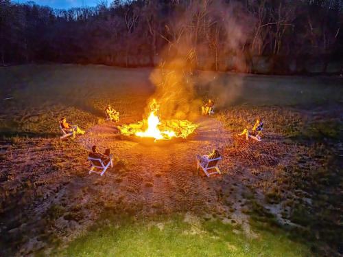 a group of people sitting around a fire at Splendid Safari Tent Sanctuary near Smoky Mountains in Tennessee in Parrottsville