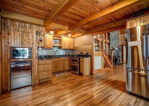 a large kitchen with wooden cabinets and stainless steel appliances at Incredible Lakeside Cabin Rental Situated near Walker Bay in Minnesota in Ah-gwah-ching
