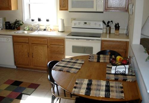 a kitchen with a wooden table and a stove top oven at Charming Cottage Overlooking Gorgeous Citation Bass and Bream Pond near Charlottesville in Gordonsville