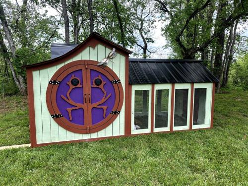 a dog house with a large door in the grass at Splendid Safari Tent Sanctuary near Smoky Mountains in Tennessee in Parrottsville