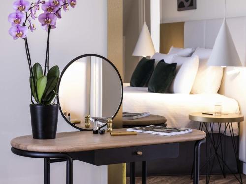 Кровать или кровати в номере Le Louis Hotel Versailles Château - MGallery Collection