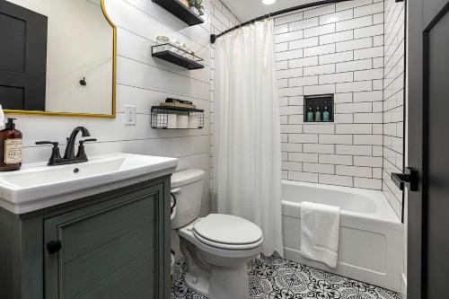 ein Badezimmer mit Waschbecken, Toilette und Badewanne in der Unterkunft Stunning Modern Cabin with Hot-tub in Makanda, illinois in Goreville